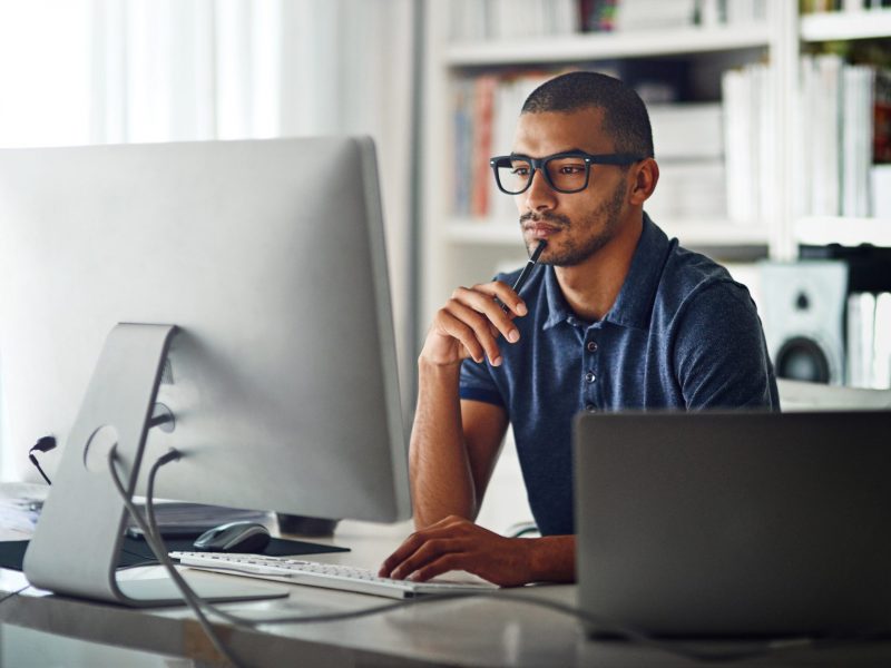 Cropped shot of a businessman using his computer in his home office