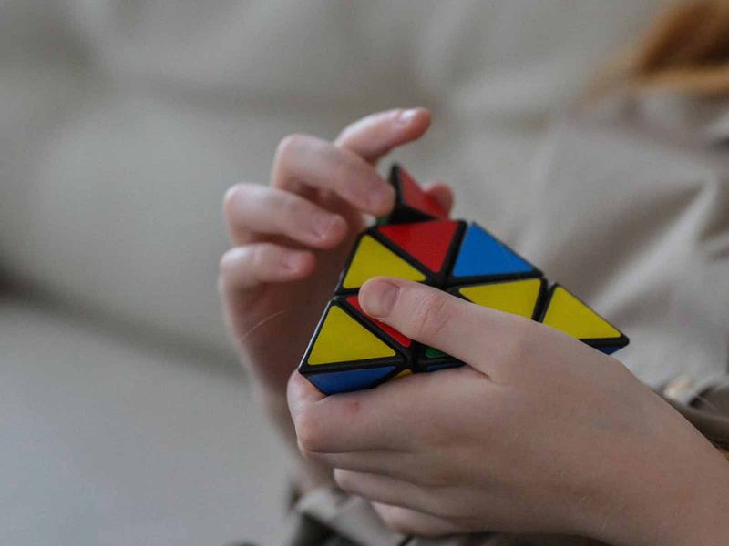 person attempting rubik's pyramid